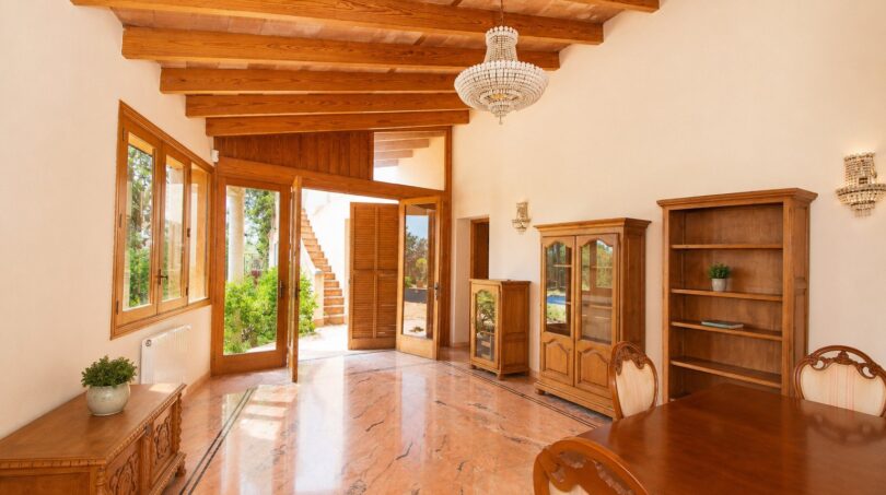 Helles Wohnzimmer der Finca Marratxí mit Holzbalkendecke, Marmorboden und Kristalllüster
