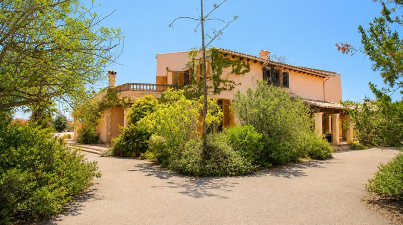 Außenansicht der Finca in Marratxí mit mediterraner Fassade, Balkon, Veranda und üppigem Grün.