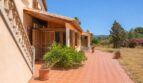 Sonnige Terrasse der Finca in Marratxí mit Terrakottafliesen, Holzläden und mediteraner Bepflanzung