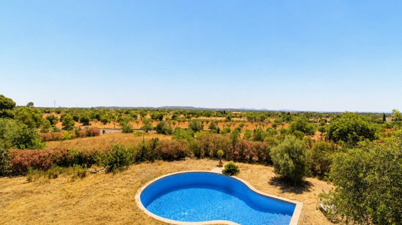 Nierenförmiger Pool der Finca in Marratxí mit Panoramablick über mediterrane Landschaft und Olivenhaine.