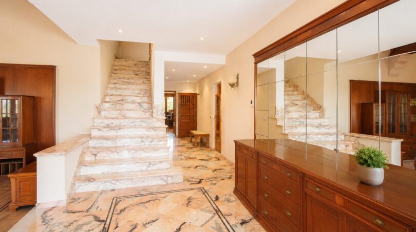 Eleganter Eingangsbereich der Finca in Marratxí mit Marmortreppe, Marmorboden und hochwertigen Holzmöbeln