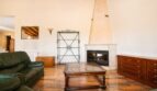 Wohnzimmer der Finca in Marratxí mit Kamin, Holzbalkendecke, Ledersofa und Marmorboden.