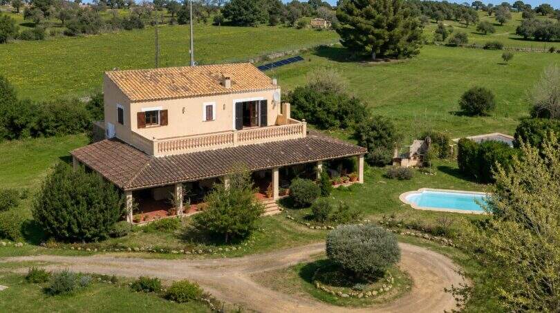 Luftaufnahme einer mallorquinischen Finca in Lloseta mit Pool, Terrasse und grüner Landschaft.