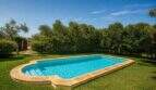 Privater Pool mit Natursteinrand, umgeben von üppigem Grün der mallorquinischen Finca in Lloseta
