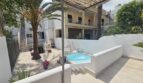 Sunny courtyard with small pool, palm trees and terrace of a modern apartment in Portocolom