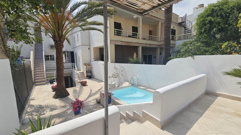 Sunny courtyard with small pool, palm trees and terrace of a modern apartment in Portocolom