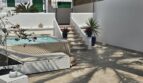 Sunny terrace with jacuzzi, lounge furniture and staircase access in modern apartment in Portocolom