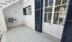 Covered terrace with air conditioning, dark shutters and tiled floor in Portocolom apartment