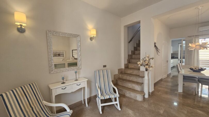 Bright entrance area with marble staircase, rocking chairs and mirror in Mediterranean style, Portocolom apartment