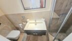 Modern bathroom with shower cubicle, wall-mounted toilet and elegant washbasin in Portocolom apartment