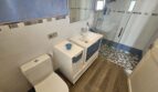 Modern bathroom with shower, washbasin and toilet in blue-white design in Portocolom apartment