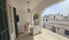 Covered terrace with lounge furniture, archways and view of Portocolom – apartment spanning 2 floors