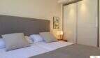 Elegante dormitorio de la villa de lujo en Cala Magrana con cama doble, armario empotrado y lámpara de mesilla