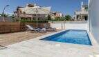 Piscina privada con terraza de madera, tumbonas y sombrilla de la villa de lujo en Cala Magrana, Porto Cristo