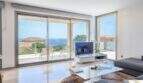 Sala de estar luminosa de la villa de lujo en Cala Magrana con acristalamiento panorámico y vistas espectaculares al mar