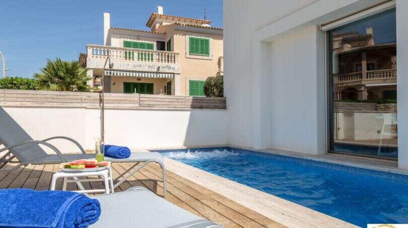 Terraza soleada con piscina privada, tumbonas y ambiente mediterráneo de la villa de lujo en Cala Magrana