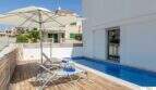 Terraza soleada con piscina, tumbonas y sombrilla de la villa de lujo en Cala Magrana, Porto Cristo