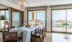 Elegante comedor de la villa de lujo en Cala Magrana con lámpara de cristal y vistas panorámicas al mar