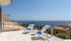 Terraza soleada de la villa de lujo en Cala Magrana con tumbonas y vistas espectaculares al Mediterráneo