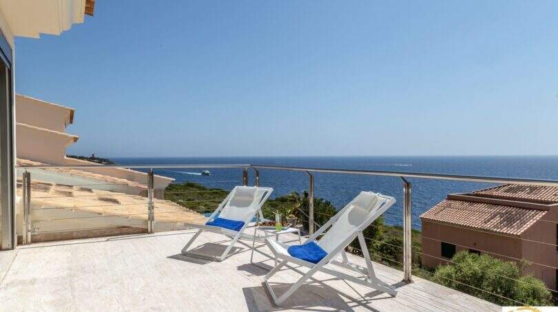 Terraza soleada de la villa de lujo en Cala Magrana con tumbonas y vistas espectaculares al Mediterráneo