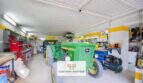 Werkstattgarage der Finca Son Macià mit John-Deere-Traktor, Werkzeugwänden und gelbem Wanddekor
