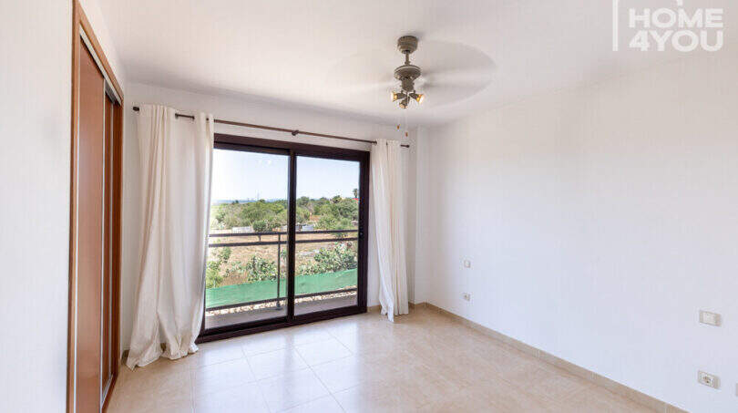 Helles Schlafzimmer mit Deckenventilator, Einbauschrank, Balkon und Grünblick im Reihenhaus Ses Salines