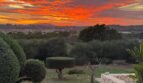 Luxusfinca Son Carrió: Gartenanlage mit spektakulärem Sonnenuntergang und weitem Panoramablick über die Landschaft.