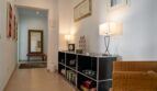 Eleganter Flurbereich der Luxusfinca in Son Carrió mit schwarzem Sideboard, Dekorleuchten und goldenem Wandspiegel.