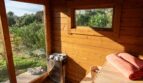 Holzsauna mit Saunaofen, Ruheliege und Panoramablick auf die grüne Landschaft der Luxusfinca in Son Carrió