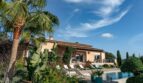 Luxusfinca Son Carrió: mediterrane Villa mit Pool, Liegestühlen, Palmen und tropischem Garten unter blauem Himmel.