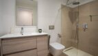 Modernes Badezimmer der Luxusfinca in Son Carrió mit Walk-in-Dusche, Holzwaschtisch und WC.
