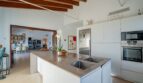 Moderne Einbauküche mit Kochinsel, Bosch-Geräten und Blick ins Wohnzimmer der Luxusfinca in Son Carrió
