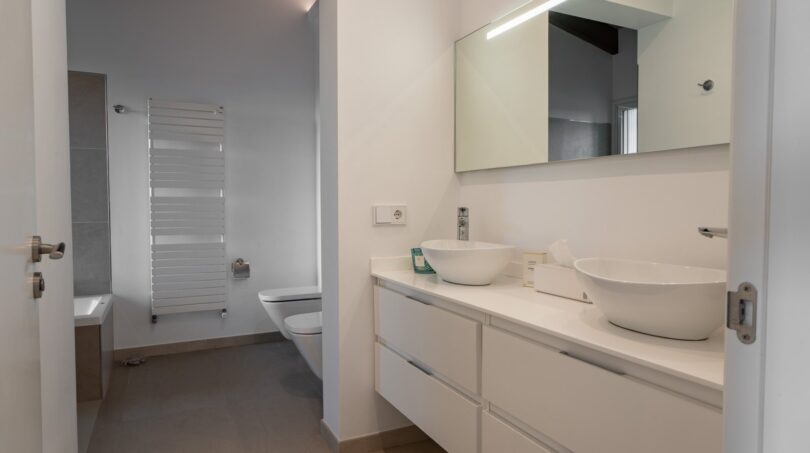 Modernes Badezimmer der Luxusfinca in Son Carrió mit Doppelwaschbecken, Spiegel und Handtuchheizkörper