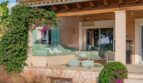 Luxusfinca Son Carrió: Elegante Terrasse mit mintgrüner Lounge, Holzveranda und mediterranem Garten mit Bougainvillea