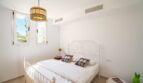 Helles Schlafzimmer der Luxusfinca in Son Carrió mit weißem Metallbett, Tiffany-Lampe und Klimaanlage.