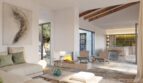 Helles Wohnzimmer der Finca Artà mit Kamin, Holzbalken, offenem Essbereich und mediterran-modernem Design.