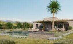 Außenansicht Neubau-Finca Artà mit Pool, Natursteinmauern, Palme und mediterranem Garten
