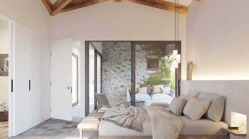 Helles Schlafzimmer mit Holzbalkendecke, Natursteinboden und Terrassenzugang in exklusiver Neubau-Finca, Artà