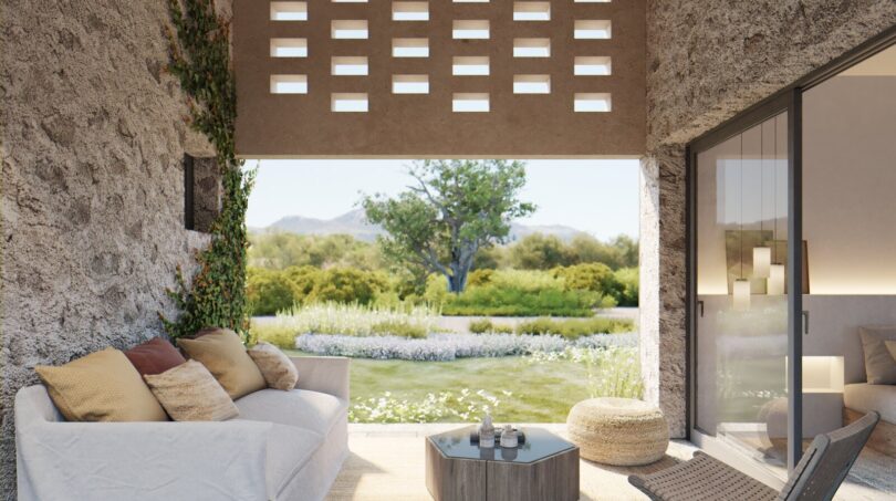 Überdachte Terrasse mit Natursteinwänden, weißem Sofa und Blick auf mediterranen Garten, Finca Artà