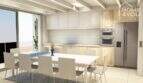 Moderne Küche mit Holzfronten, Einbaugeräten und angrenzendem Essbereich, Bauprojekt S'Alqueria Blanca