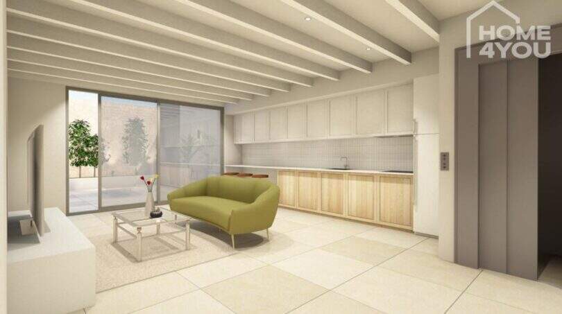 Offener Wohn-Küchenbereich mit Holzküche, Exposed-Beam-Decke, grünem Sofa und Aufzug in S'Alqueria Blanca