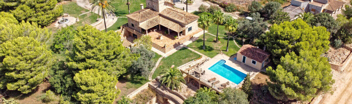 Luftaufnahme einer exklusiven Finca in Colònia de Sant Jordi mit Pool, Palmen und weitläufigem Grundstück.