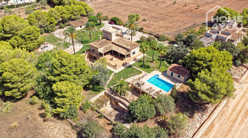 Luftaufnahme einer exklusiven Finca in Colònia de Sant Jordi mit Pool, Palmen und weitläufigem Grundstück.