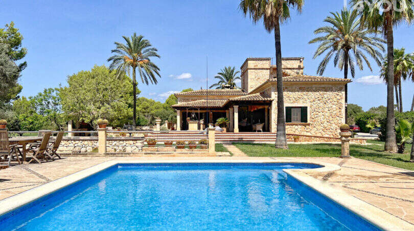 Außenansicht: Exklusive Finca mit großem Pool, Natursteinhaus, Palmen und gepflegtem Garten in Colònia de Sant Jordi.