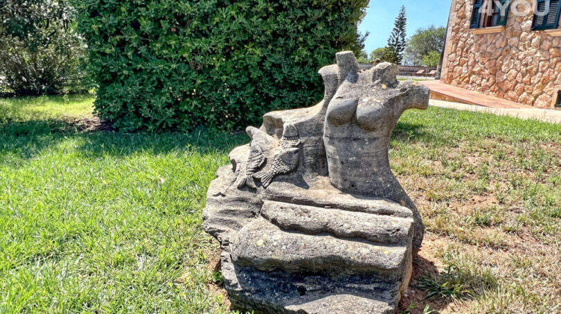 Steinskulptur mit Fischmotiv im gepflegten Garten der exklusiven Finca in Colònia de Sant Jordi