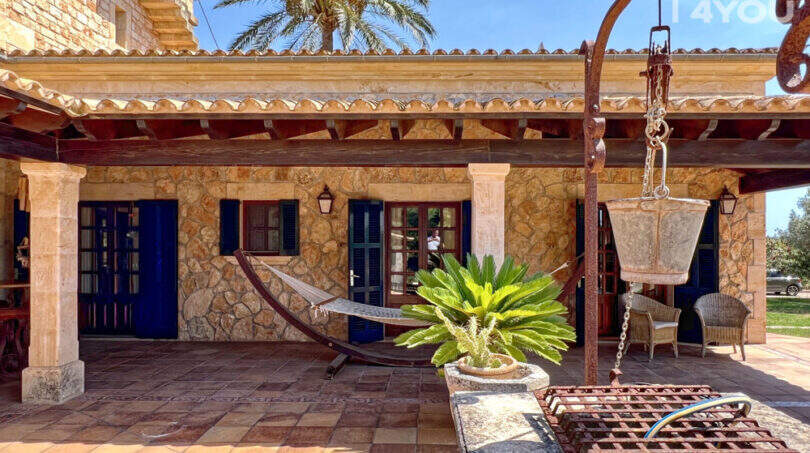 Rustikale Finca-Terrasse mit Natursteinmauer, Hängematte, Pergola und Palmen in Colònia de Sant Jordi