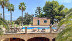 Finca Colònia de Sant Jordi: Poolterrasse mit Sandsteinbögen, Loungemöbeln, Poolhaus und Palmen