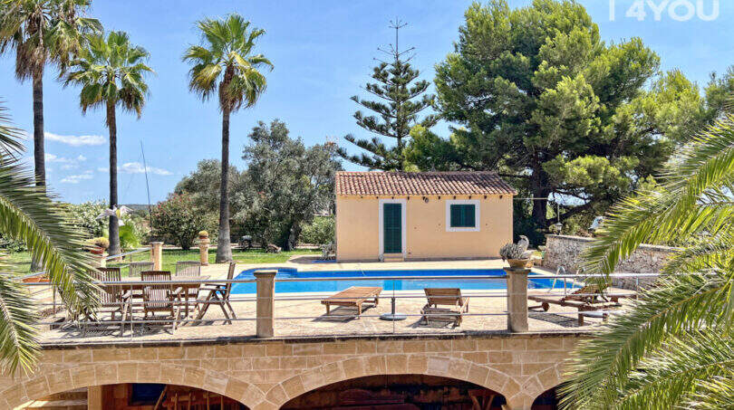 Finca Colònia de Sant Jordi: Poolterrasse mit Sandsteinbögen, Loungemöbeln, Poolhaus und Palmen