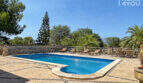 Großer Pool mit Natursteinteasse, Liegestühlen und üppigem Grün der exklusiven Finca in Colònia de Sant Jordi