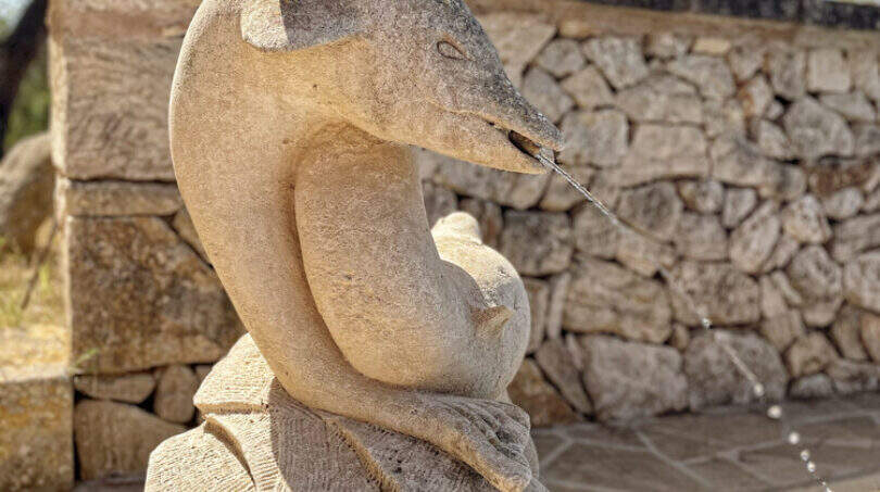 Steinbrunnen mit Delfinskulptur am Pool der exklusiven Finca in Colònia de Sant Jordi